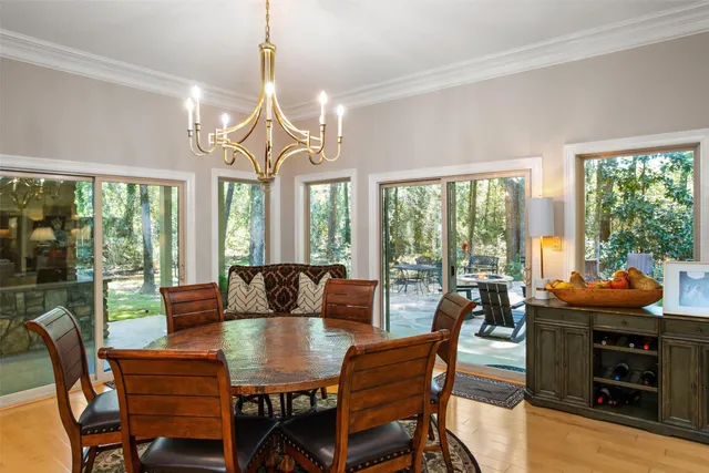 a dining room with furniture large windows and a chandelier