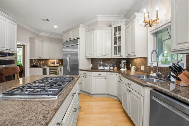 a kitchen with stainless steel appliances granite countertop a sink stove and refrigerator