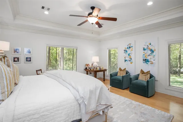 a spacious bedroom with a bed couches and a chandelier