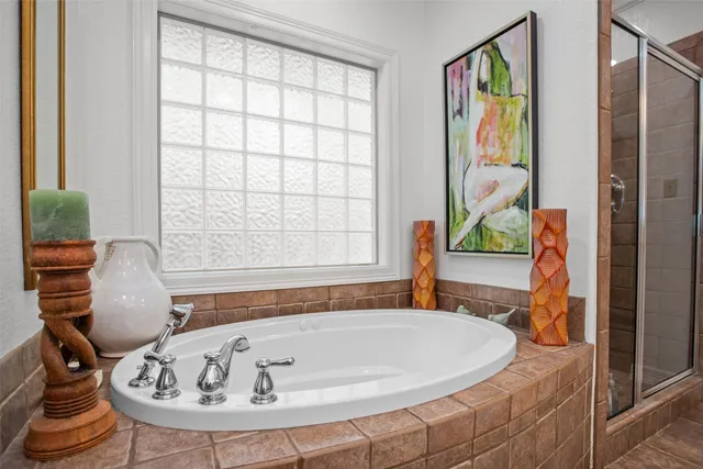 a white bath tub sitting in a bathroom next to a window