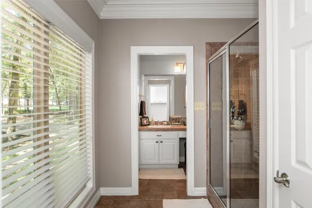 a bathroom with a sink toilet a mirror and next to a window
