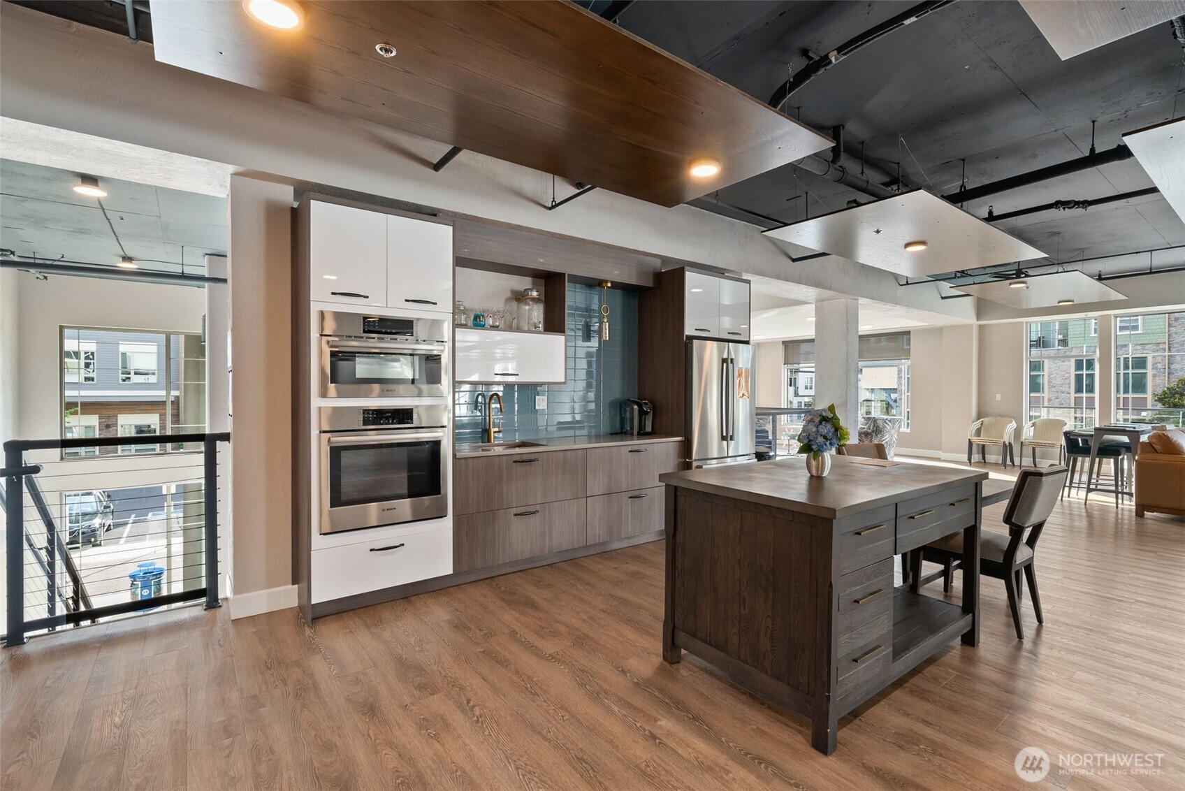 4961 Main Street, Unit 710 Tacoma, WA 98407 - Photo 24 of 24 a kitchen with stainless steel appliances kitchen island granite countertop a table chairs and a refrigerator