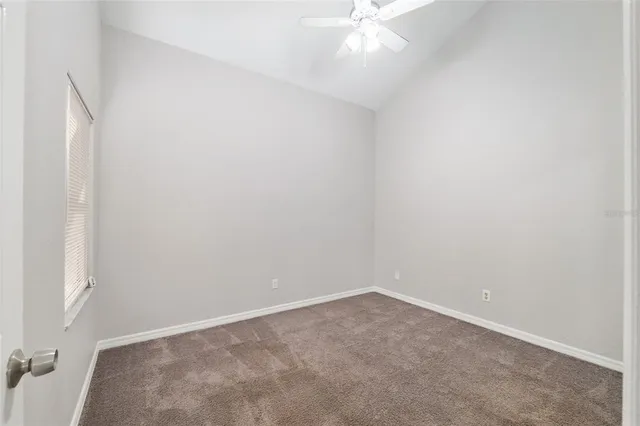 an empty room with a chandelier fan
