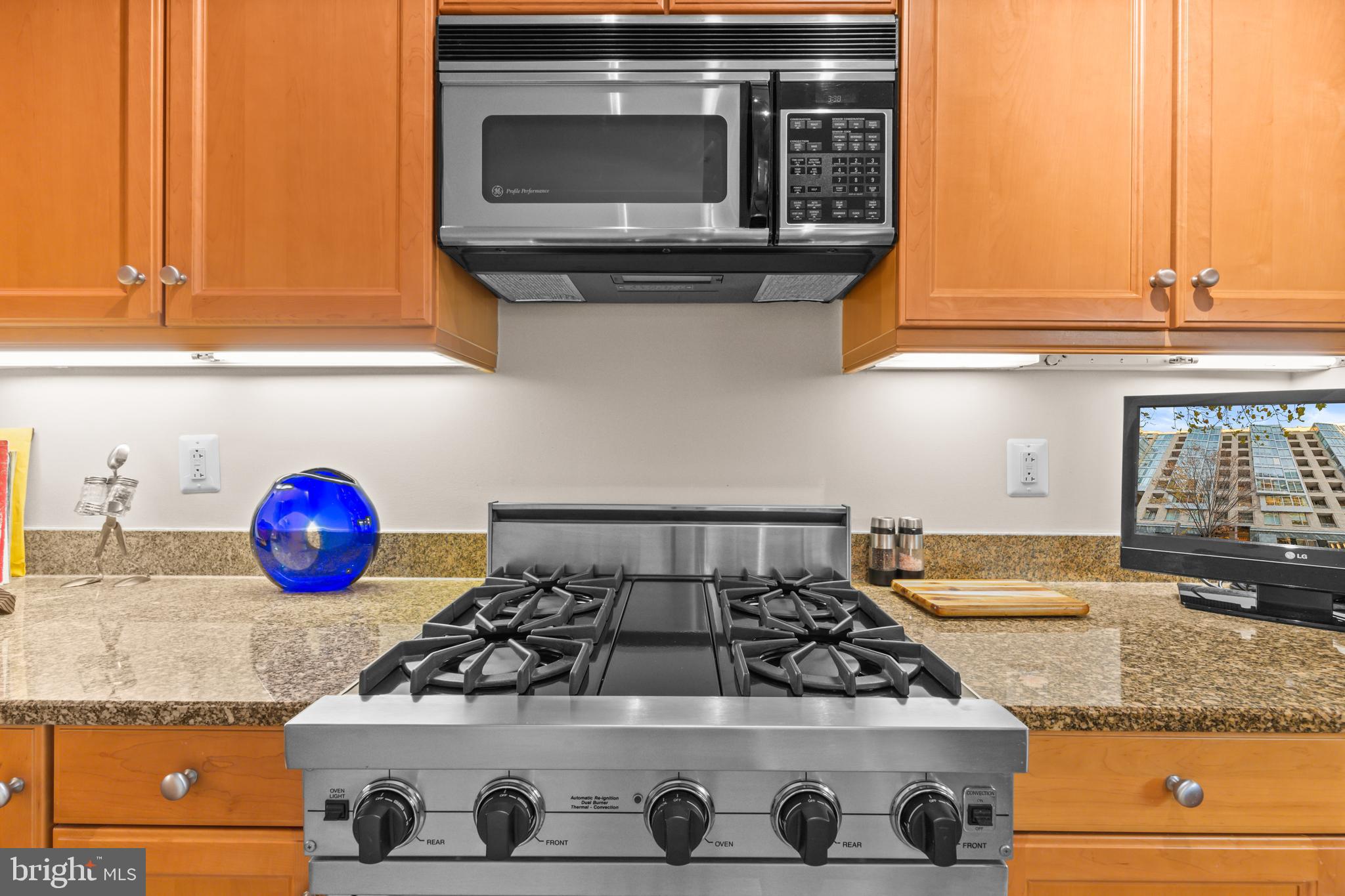 1111 23rd Street Northwest, Unit 4G Washington, DC 20037 - Photo 11 of 35 a kitchen with a stove and a microwave