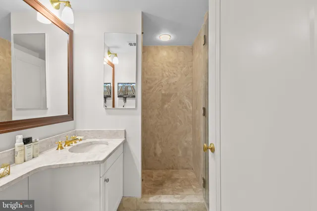 a bathroom with a granite countertop sink and a mirror