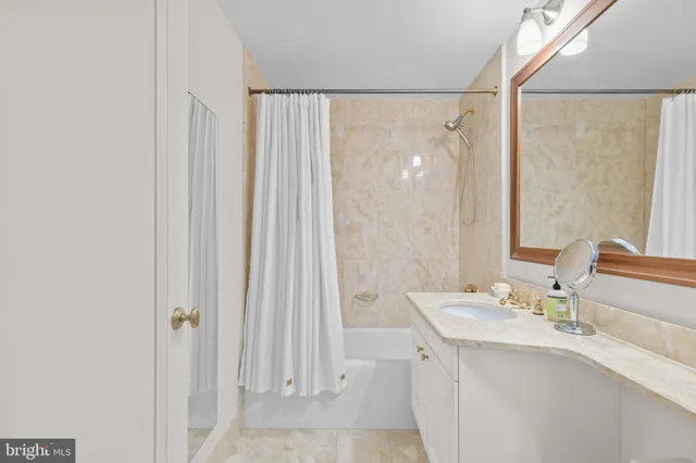 a bathroom with a granite countertop sink a mirror and a shower