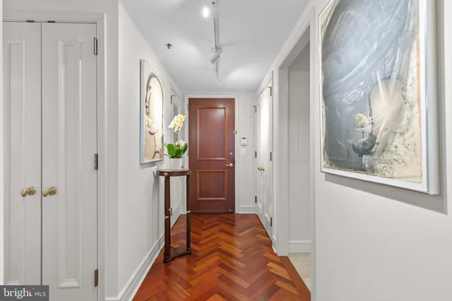a view of a hallway with wooden floor and windows