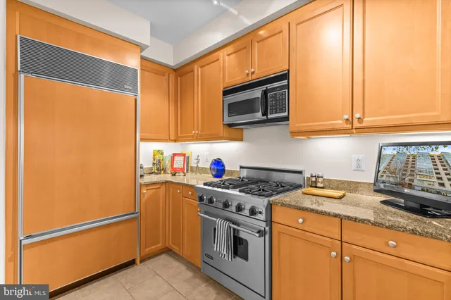 a kitchen with stainless steel appliances granite countertop a refrigerator sink and cabinets