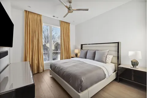 a bedroom with a bed and a flat tv screen on dresser