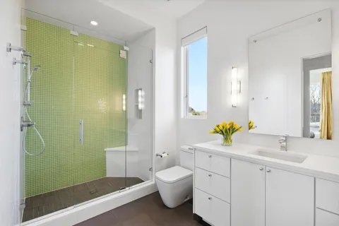a bathroom with a double vanity sink toilet and shower