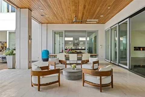 a living room with patio furniture and potted plants