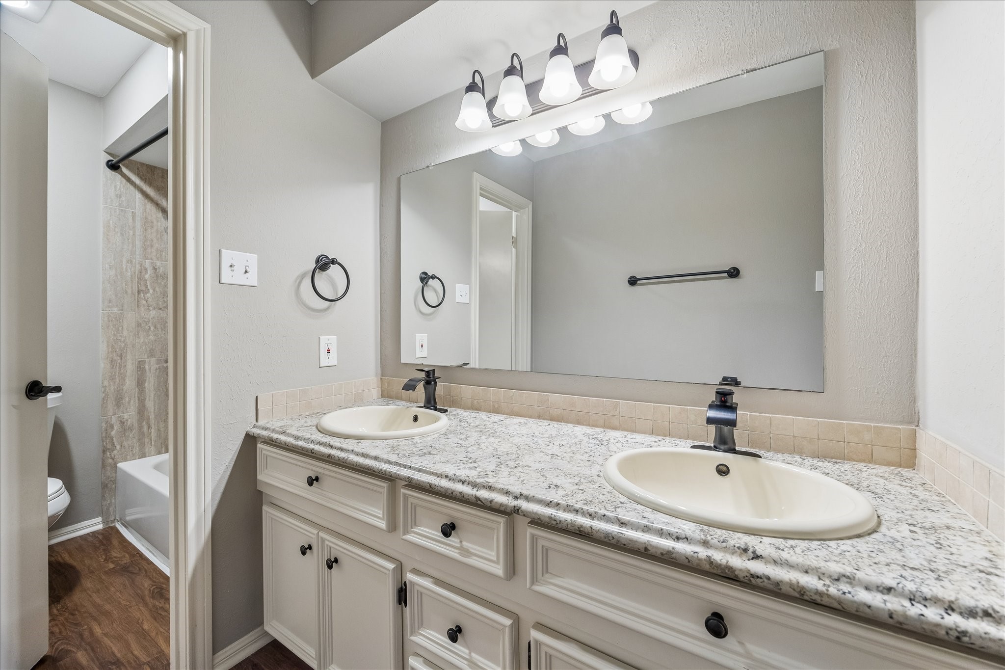 15066 Kimberley Court Houston, TX 77079 - Photo 21 of 27 Well-appointed secondary bathroom complete with dual vanities and a shower/bath combo. A door provides separation and privacy when needed from the vanity area.