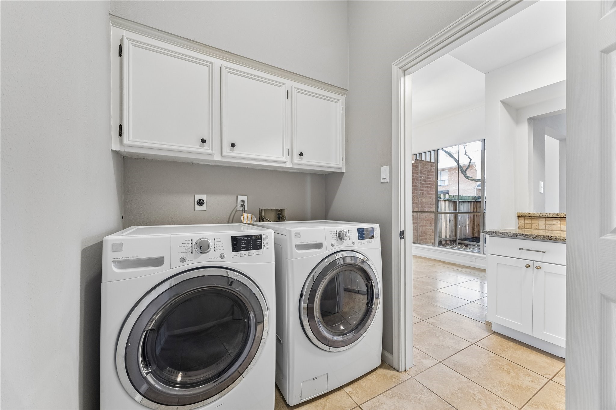 15066 Kimberley Court Houston, TX 77079 - Photo 23 of 27 The downstairs laundry room between the kitchen and breakfast room features an included front loader washer & dryer, plus overhead storage.