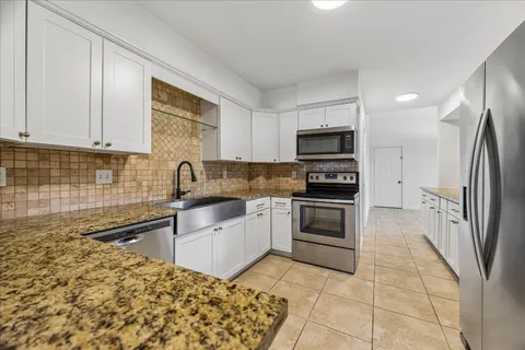 a kitchen with stainless steel appliances granite countertop a refrigerator stove and microwave