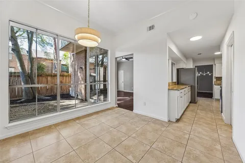 a view of an empty room with wooden floor fireplace and a window