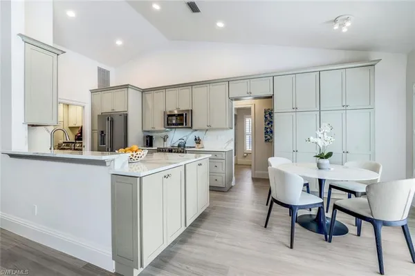 a kitchen with stainless steel appliances white cabinets and wooden floor
