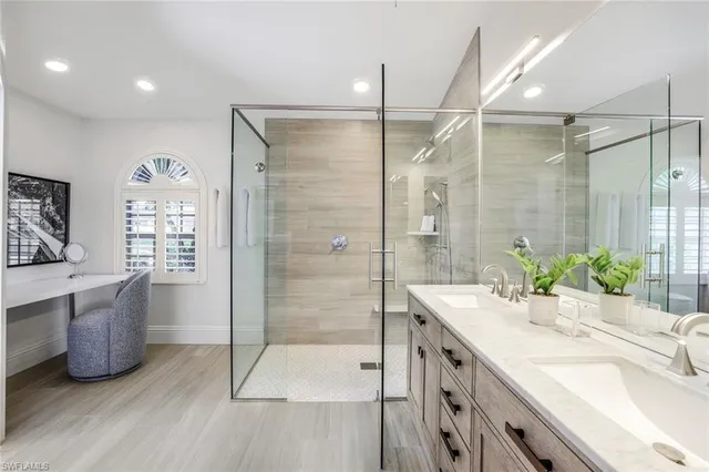 a bathroom with a double vanity sink a large mirror and shower