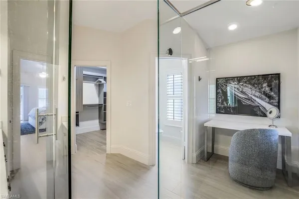 a view of a hallway with bathroom and wooden floor