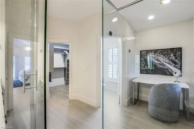a view of a hallway with bathroom and wooden floor