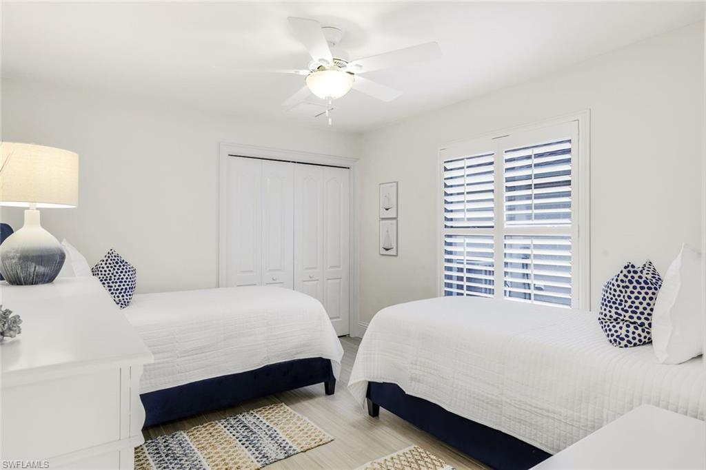 914 Marble Drive Naples, FL 34104 - Photo 22 of 50 a bedroom with a bed and a table with lamp