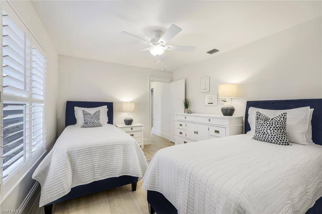 914 Marble Drive Naples, FL 34104 - Photo 23 of 50 a bedroom with two beds and a chandelier