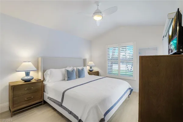 a bedroom with a bed and a flat tv screen on dresser