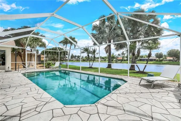 a view of a swimming pool with a patio and a yard