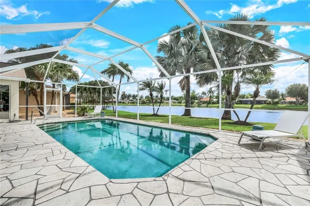 a view of a swimming pool with a patio and a yard