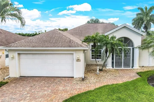 a view of a house with a yard and potted plants