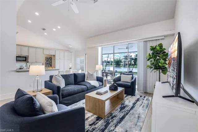 a living room with furniture a large window and a flat screen tv