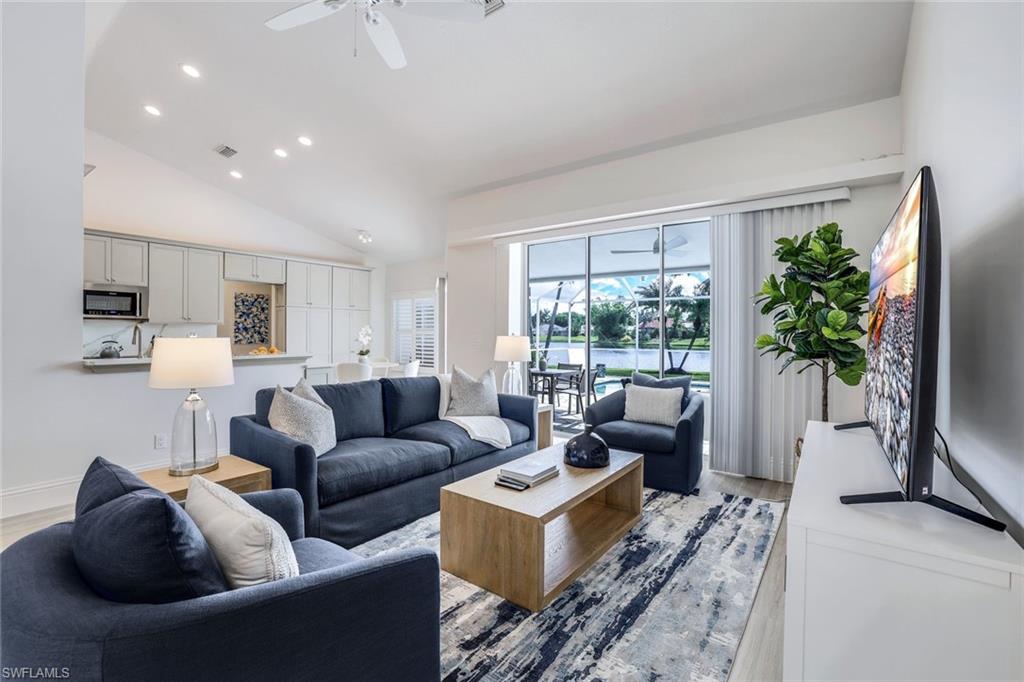 914 Marble Drive Naples, FL 34104 - Photo 5 of 50 a living room with furniture a large window and a flat screen tv