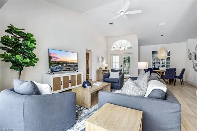 a living room with furniture a chandelier and a flat screen tv
