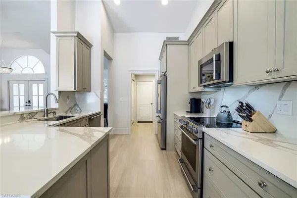 a kitchen with granite countertop a sink a stove and cabinets