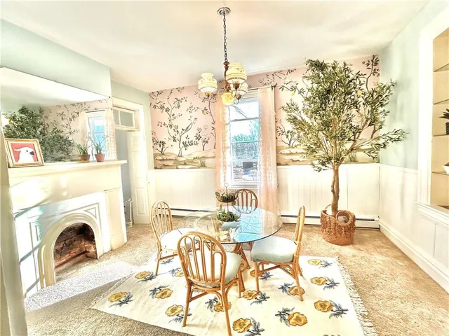 a living room with furniture a fireplace and a floor to ceiling window