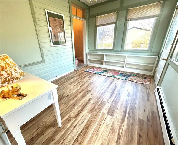 a view of a bedroom with wooden floor and a window