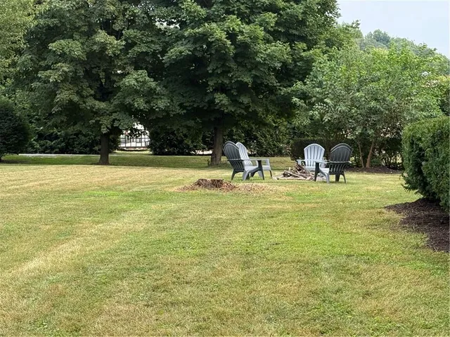 a group of chairs sitting in a yard with wooden fence