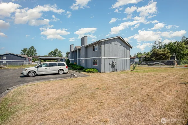 a view of a car parked in front of a house with a yard