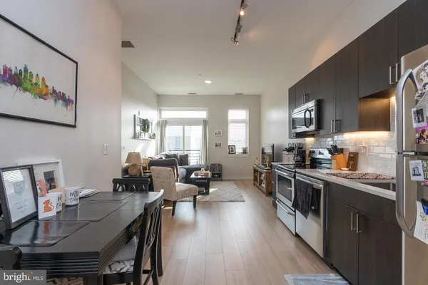 a large kitchen with stainless steel appliances lots of counter space dining table and chairs