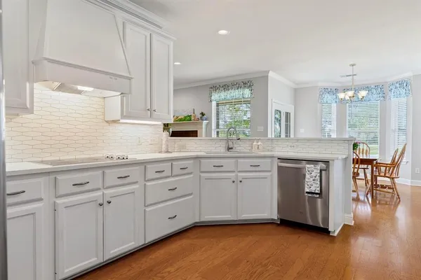 a kitchen with white cabinets sink and window
