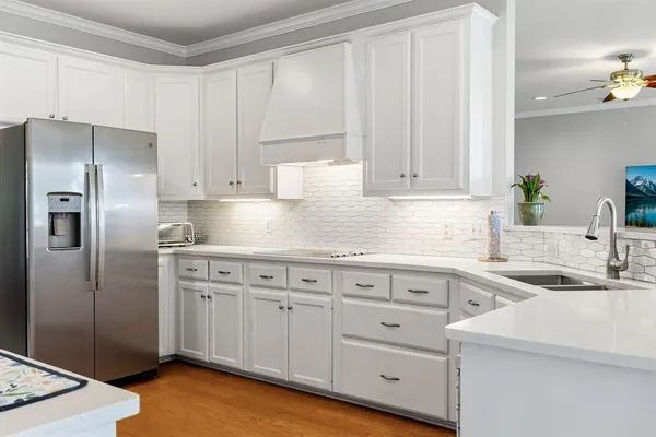 a kitchen with white cabinets and stainless steel appliances