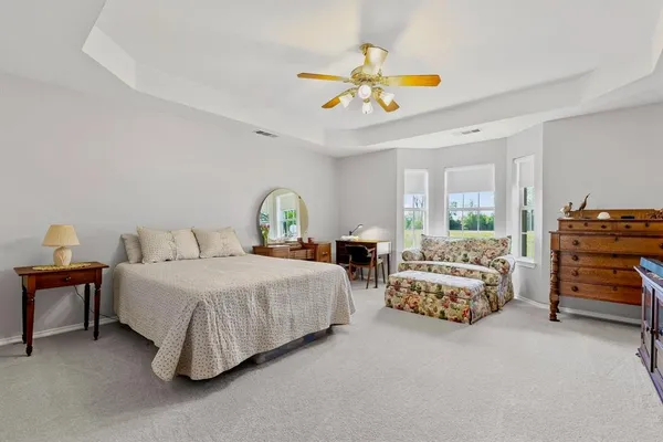 a spacious bedroom with a bed and a chandelier