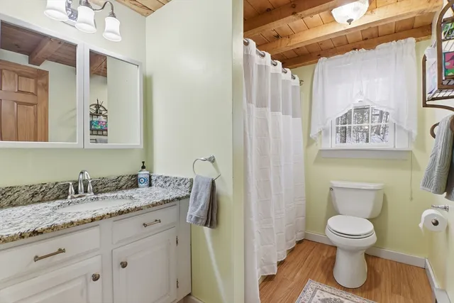a bathroom with a granite countertop toilet sink and mirror