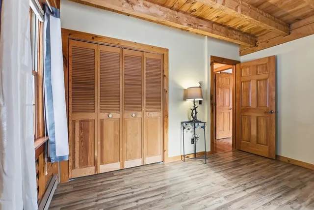 a view of empty room with wooden floor and windows