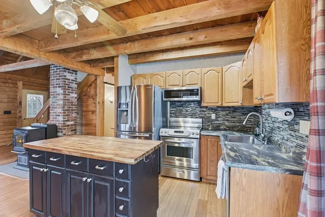 a kitchen with stainless steel appliances granite countertop a sink and wooden cabinets