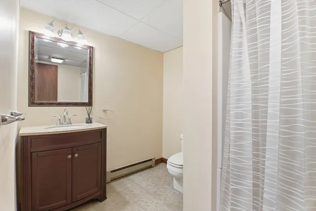 a bathroom with a toilet a sink and mirror