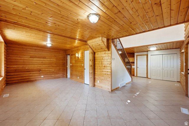2640 East Weber Canyon Road Oakley, UT 84055 - Photo 18 of 56 Pine wood paneling, tiled flooring, built-in staircase, and bi-fold closet doors