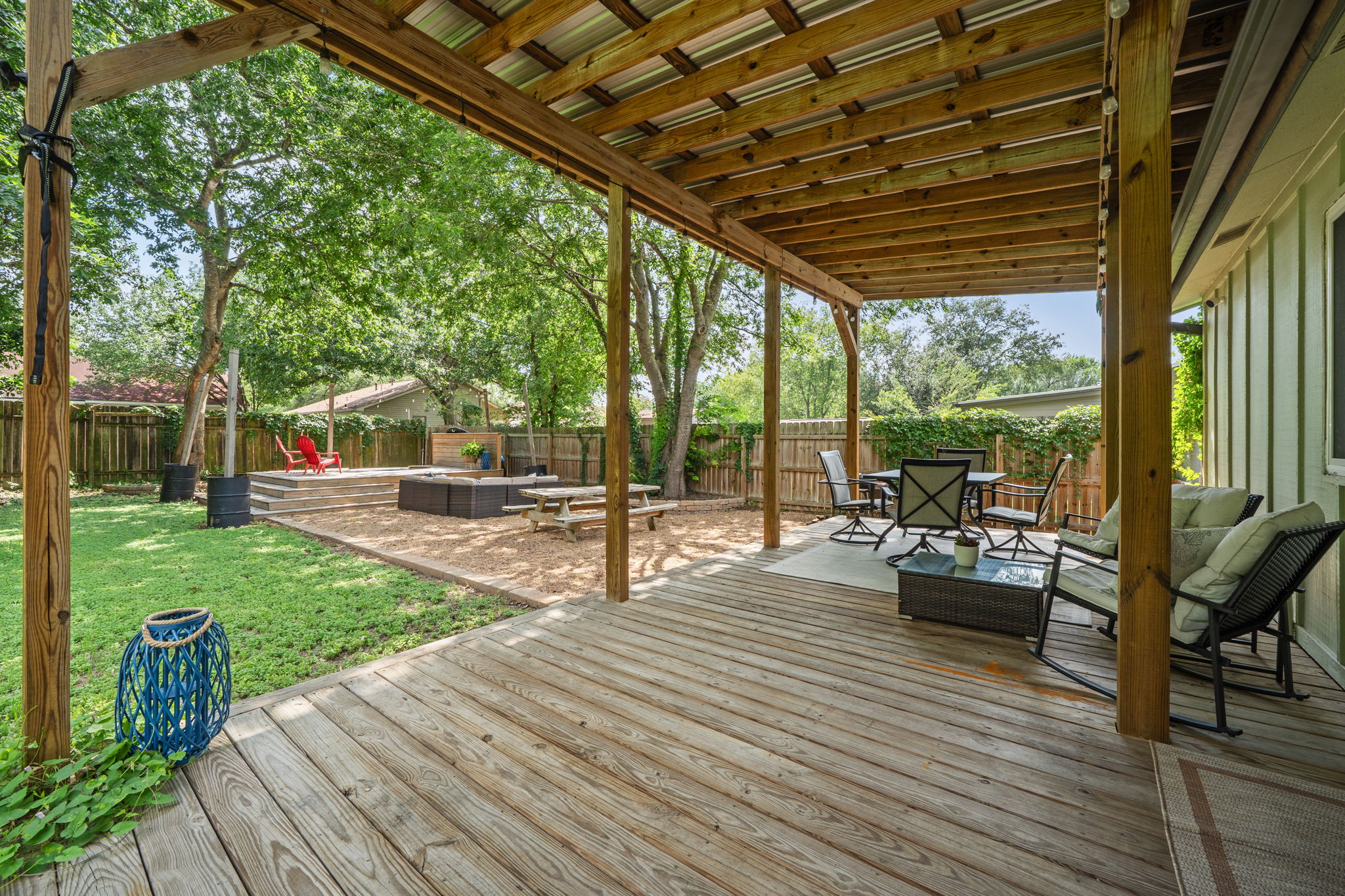 705 Dulwich Street Austin, TX 78748 - Photo 21 of 36 A spacious backyard retreat features a covered deck, ample green space, and a tiered fire pit area.