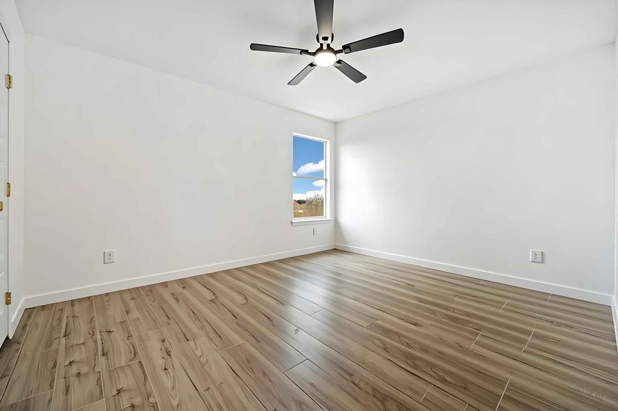 13501 Sierra Wind Lane Elgin, TX 78621 - Photo 8 of 19 Bright interior space featuring wood-finish flooring, white walls, and a ceiling fan with integrated lighting