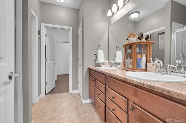 a spacious bathroom with a granite countertop sink a mirror and a shower