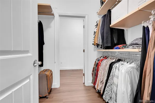a view of walk in closet with clothes and shoes